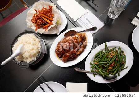 Three flavorful Chinese dishes served together for a perfect feast, stir fried string beans with minced pork, crispy basket with savory shredded pork, and roasted duck with caramelized glaze. Three flavorful Chinese dishes served together for a perfect feast, stir fried string beans with minced pork, crispy basket with savory shredded pork, and roasted duck with caramelized glaze. 123686654