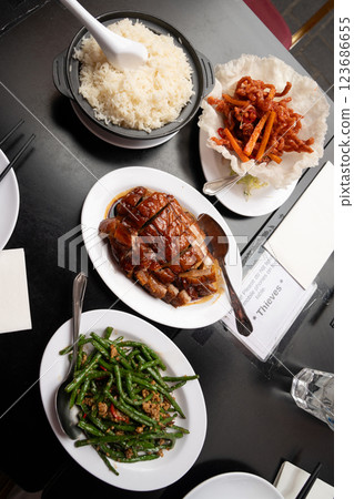 Three flavorful Chinese dishes served together for a perfect feast, stir fried string beans with minced pork, crispy basket with savory shredded pork, and roasted duck with caramelized glaze. 123686655