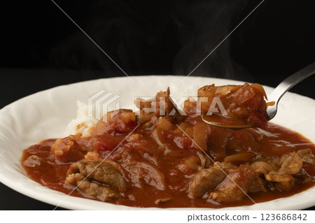 用湯匙將熱騰騰的牛肉乾米飯舀起來 用湯匙將熱騰騰的牛肉乾米飯舀起來 123686842