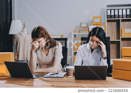 Startup SME small business entrepreneur of freelance Asian woman using a laptop with box Cheerful success Asian woman her hand lifts up online marketing packaging box and delivery SME idea concept 123686856