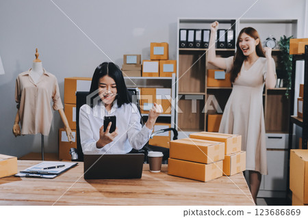 Asian SME business women use laptop computer checking customer order online shipping boxes at home. Starting Small business entrepreneur SME freelance. Online business, Work at home concept. 123686869