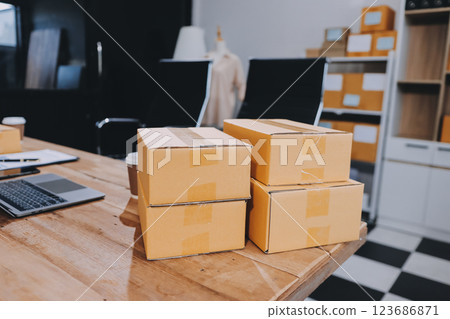 Asian SME business women use laptop computer checking customer order online shipping boxes at home. Starting Small business entrepreneur SME freelance. Online business, Work at home concept. Asian SME business women use laptop computer checking customer order online shipping boxes at home. Starting Small business entrepreneur SME freelance. Online business, Work at home concept. 123686871