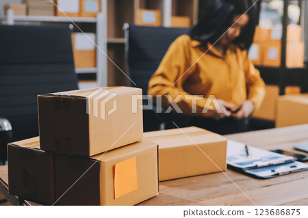 Asian SME business women use laptop computer checking customer order online shipping boxes at home. Starting Small business entrepreneur SME freelance. Online business, Work at home concept. 123686875