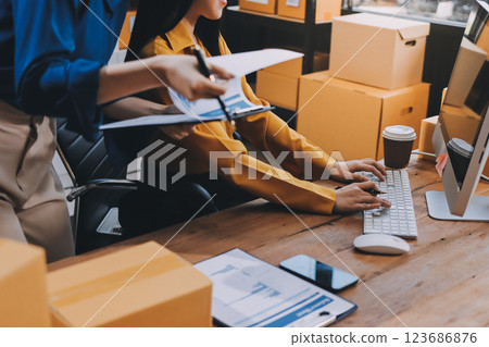 Asian SME business women use laptop computer checking customer order online shipping boxes at home. Starting Small business entrepreneur SME freelance. Online business, Work at home concept. 123686876