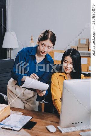 Asian SME business women use laptop computer checking customer order online shipping boxes at home. Starting Small business entrepreneur SME freelance. Online business, Work at home concept. Asian SME business women use laptop computer checking customer order online shipping boxes at home. Starting Small business entrepreneur SME freelance. Online business, Work at home concept. 123686879