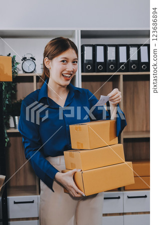 Asian SME business women use laptop computer checking customer order online shipping boxes at home. Starting Small business entrepreneur SME freelance. Online business, Work at home concept. 123686894