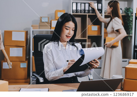 Asian SME business women use laptop computer checking customer order online shipping boxes at home. Starting Small business entrepreneur SME freelance. Online business, Work at home concept. 123686917