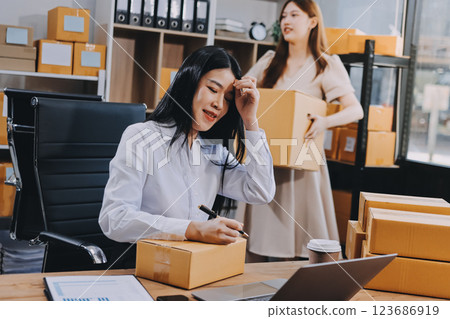 Asian SME business women use laptop computer checking customer order online shipping boxes at home. Starting Small business entrepreneur SME freelance. Online business, Work at home concept. Asian SME business women use laptop computer checking customer order online shipping boxes at home. Starting Small business entrepreneur SME freelance. Online business, Work at home concept. 123686919
