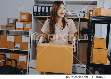 Asian SME business women use laptop computer checking customer order online shipping boxes at home. Starting Small business entrepreneur SME freelance. Online business, Work at home concept. Asian SME business women use laptop computer checking customer order online shipping boxes at home. Starting Small business entrepreneur SME freelance. Online business, Work at home concept. 123686920