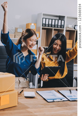 Asian SME business women use laptop computer checking customer order online shipping boxes at home. Starting Small business entrepreneur SME freelance. Online business, Work at home concept. Asian SME business women use laptop computer checking customer order online shipping boxes at home. Starting Small business entrepreneur SME freelance. Online business, Work at home concept. 123686934