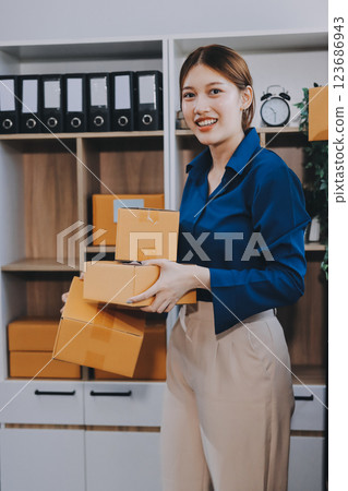 Asian SME business women use laptop computer checking customer order online shipping boxes at home. Starting Small business entrepreneur SME freelance. Online business, Work at home concept. Asian SME business women use laptop computer checking customer order online shipping boxes at home. Starting Small business entrepreneur SME freelance. Online business, Work at home concept. 123686943