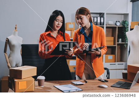 Fashion blogger concept, Young Asian women selling clothes on video streaming.Startup small business SME, using smartphone or tablet taking receive and checking in office 123686948