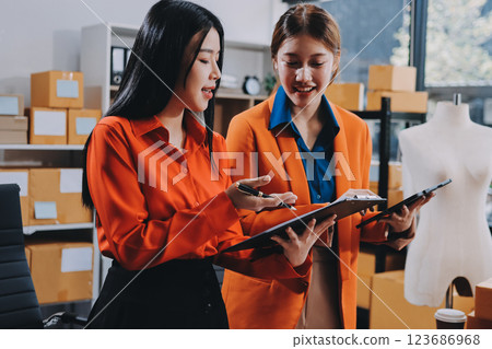 Fashion blogger concept, Young Asian women selling clothes on video streaming.Startup small business SME, using smartphone or tablet taking receive and checking in office Fashion blogger concept, Young Asian women selling clothes on video streaming.Startup small business SME, using smartphone or tablet taking receive and checking in office 123686968