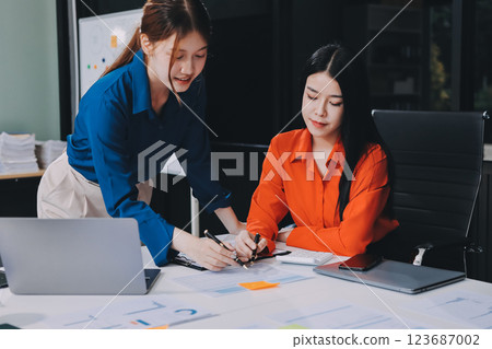 Entrepreneur Asian businessman and businesswoman discussing new business project in tablet in modern Meeting In Modern Office, Asian business casual concept. 123687002