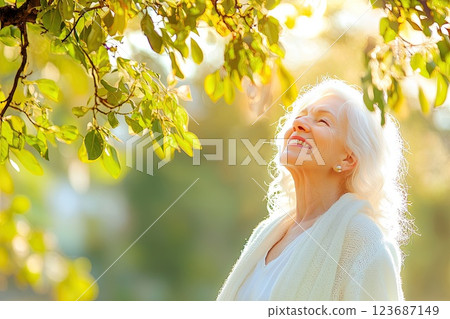 Elderly woman enjoying serene moment under sunlight surrounded by nature in a beautiful park Elderly woman enjoying serene moment under sunlight surrounded by nature in a beautiful park 123687149