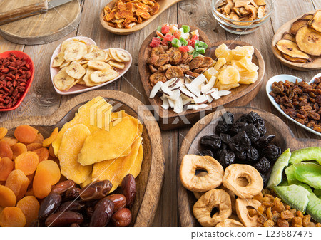 Healthy sweet dried fruits and berries in wooden heart shaped plates on wooden background.Top view. Healthy sweet dried fruits and berries in wooden heart shaped plates on wooden background.Top view. 123687475