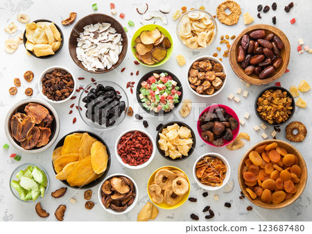 Mix of healthy dried sweet fruits and berries in various bowl plates on light kitchen background. 123687480