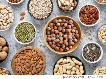 Mixed healthy nuts and seeds in various bowls on kitchen table.Peanut,hazelnut,walnut Mixed healthy nuts and seeds in various bowls on kitchen table.Peanut,hazelnut,walnut 123687491