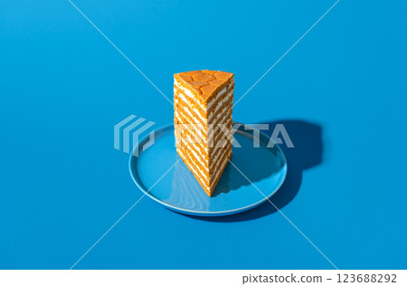 Honey layered cake slice, russian recipe, isolated on a blue background 123688292