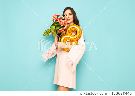 Woman hold bouquet of flowers and balloon number 8 123688446