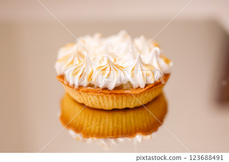 Lemon tart with whipped cream stands on a reflective surface Lemon tart with whipped cream stands on a reflective surface 123688491