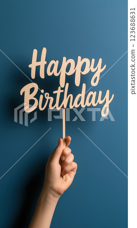 hand holds laser cut wood topper with Happy Birthday text hand holds laser cut wood topper with Happy Birthday text 123688631