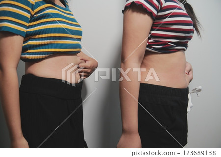 Women body fat belly. Obese woman hand holding excessive belly fat. diet lifestyle concept to reduce belly and shape up healthy stomach muscle. Women body fat belly. Obese woman hand holding excessive belly fat. diet lifestyle concept to reduce belly and shape up healthy stomach muscle. 123689138
