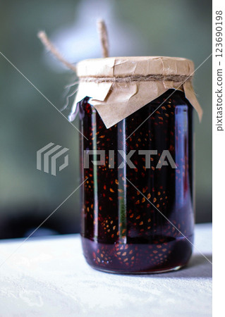 Pine cone jam jar with kraft lid and rope decoration 123690198