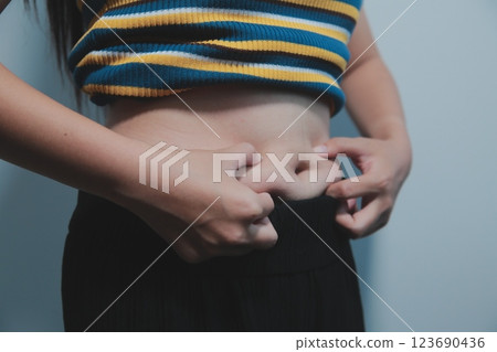 Women body fat belly. Obese woman hand holding excessive belly fat. diet lifestyle concept to reduce belly and shape up healthy stomach muscle. Women body fat belly. Obese woman hand holding excessive belly fat. diet lifestyle concept to reduce belly and shape up healthy stomach muscle. 123690436