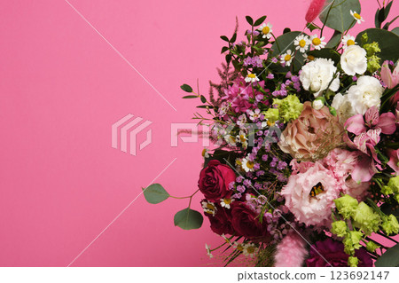 A brightly colored floral bouquet on a pink background. Roses, carnations, eustoma, alstromeria. Copyspace 123692147