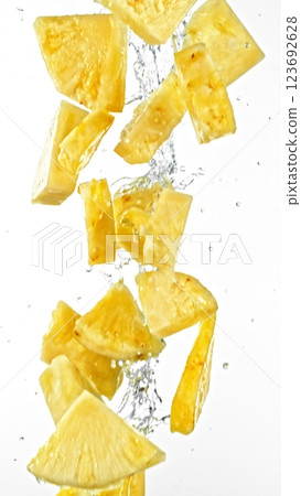 Fresh pineapple slices falling in water splashes, isolated on white background. Fresh pineapple slices falling in water splashes, isolated on white background. 123692628