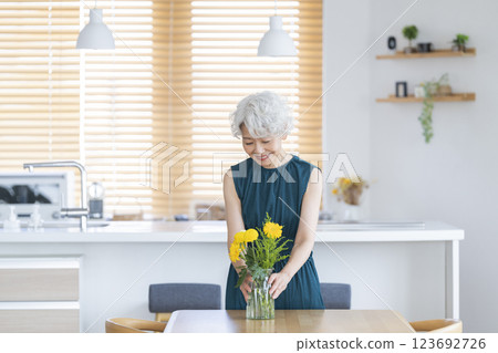 在家裝飾鮮花的老年婦女 在家裝飾鮮花的老年婦女 123692726
