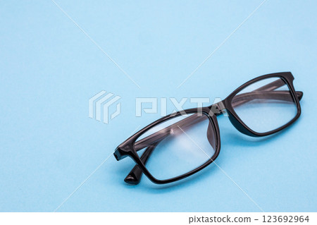 Black-rimmed glasses on a light blue background 123692964