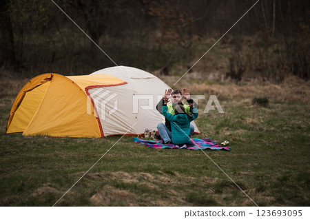 Family bonding time in nature by a cozy tent during a crisp evening, enjoying laughter and warmth under the vast sky 123693095
