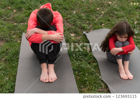 Emotional connection between a young boy and girl during a mindful moment in a serene park on a chilly afternoon while practicing self-reflection 123693115