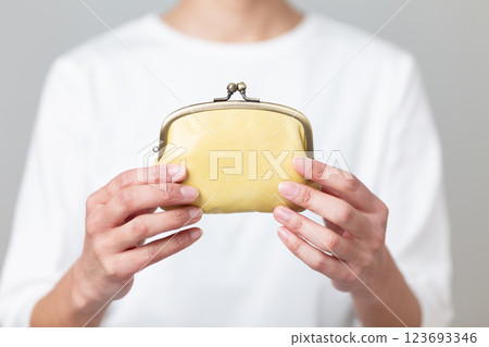 Middle-aged woman holding a yellow purse Middle-aged woman holding a yellow purse 123693346