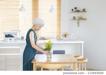 一位老年婦女在家中裝飾鮮花的簡介 123693600