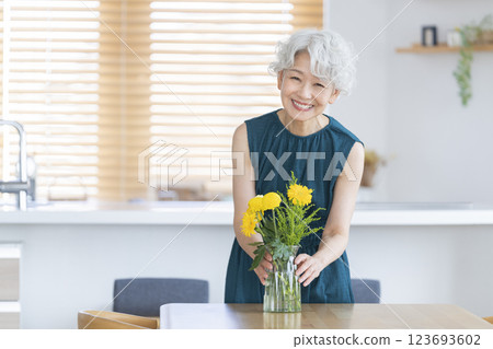 微笑的老年婦女在家中裝飾鮮花 123693602