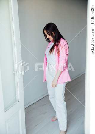 woman in suit with pink jacket in white room interior woman in suit with pink jacket in white room interior 123693803