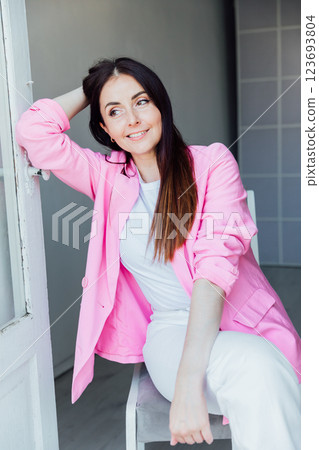 woman in suit with pink jacket in white room interior woman in suit with pink jacket in white room interior 123693804