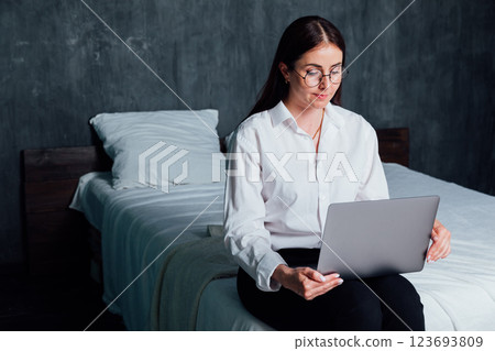 Woman working on laptop online at home on bed 123693809