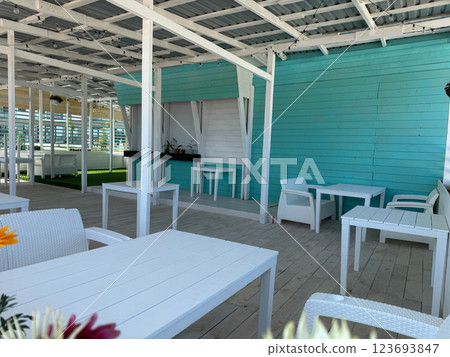 Interior of a summer wooden restaurant with tables without people Interior of a summer wooden restaurant with tables without people 123693847