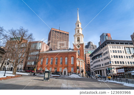 View of Park Street Church and surrounded buildings in Boston during winter with snow on the Boston Common ground against clear blue sky 123693966