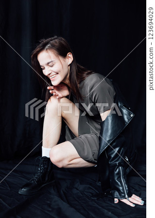 Beautiful fashionable slim woman in green summer and jacket on black background Beautiful fashionable slim woman in green summer and jacket on black background 123694029