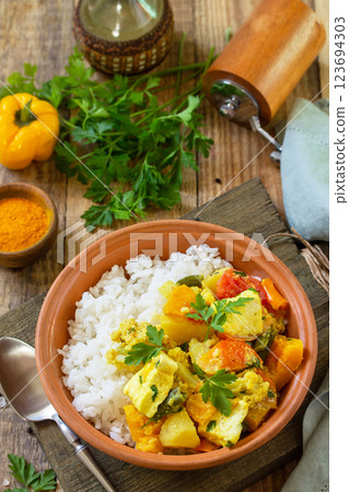 Indian cuisine dish sabji. Traditional Indian vegetable stew with soft cheese, turmeric and rice on a wooden table. Indian cuisine dish sabji. Traditional Indian vegetable stew with soft cheese, turmeric and rice on a wooden table. 123694303