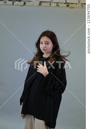 Female with hair billowing, captures the essence of a light-hearted day. Represents the ease of youth and natural elegance. 123694700