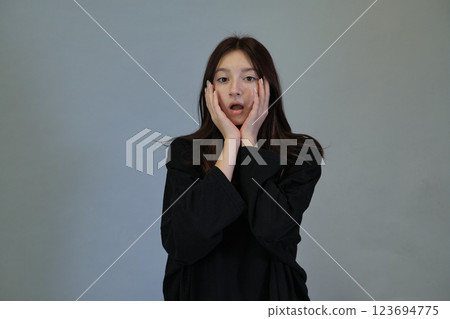 Astonished young lady, palms supporting her face. Depicts authentic reactions, vital in today's realistic media. Astonished young lady, palms supporting her face. Depicts authentic reactions, vital in today's realistic media. 123694775