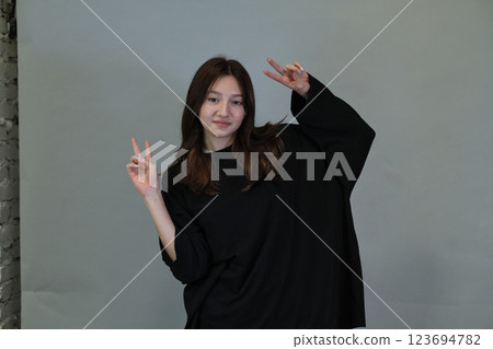 Teenager flashes a peace symbol, connecting to global calls for harmony. Emphasizes current social movements. 123694782