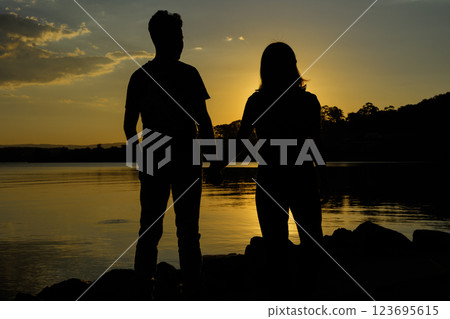 Couple holding hands by the sea at sunset 123695615