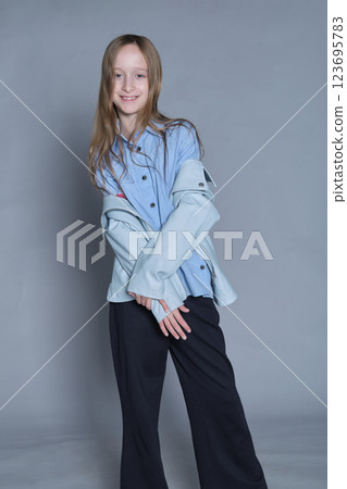 Girl with a cheeky smile, clad in modern attire, embodies lighthearted fashion. Ideal for youth lifestyle brands. Girl with a cheeky smile, clad in modern attire, embodies lighthearted fashion. Ideal for youth lifestyle brands. 123695783